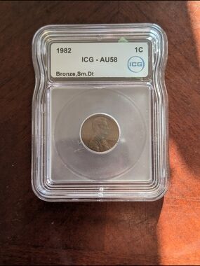 Graded 1982 Small Date Penny (AU58) in Clear Coin Holder.